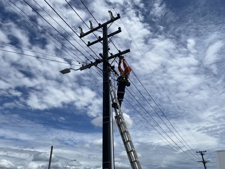man working at overhead power supplies